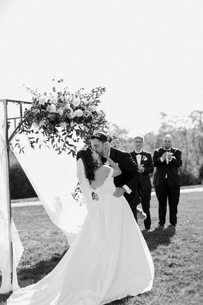 Bride and groom kissing under the chuppah