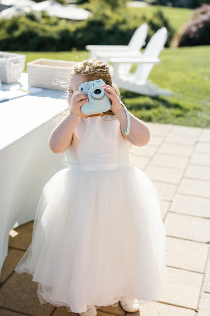 Flower girl taking a polaroid photo