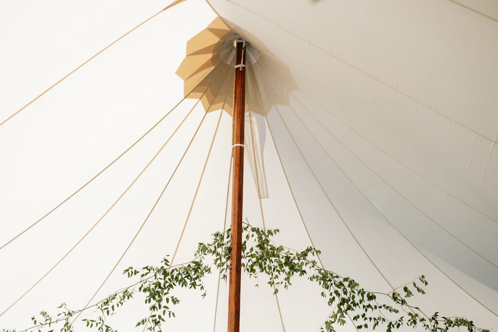 White Sperry wedding tent with hanging greens