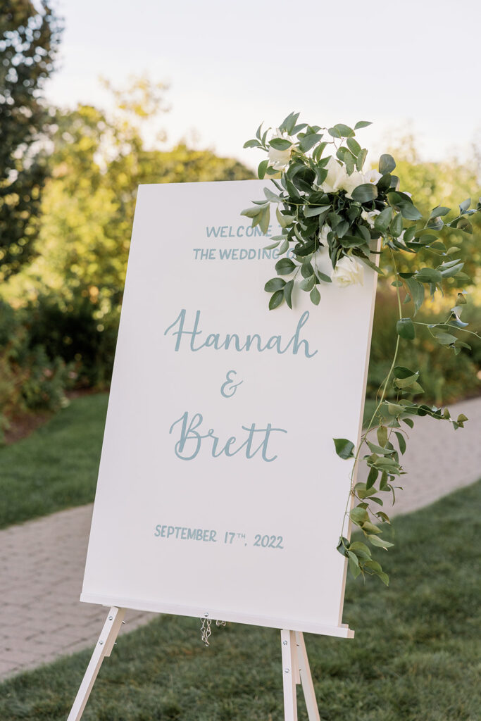 Wedding welcome sign with blue cursive and greens
