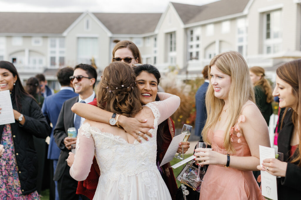 A guest hugs the bride among other guests