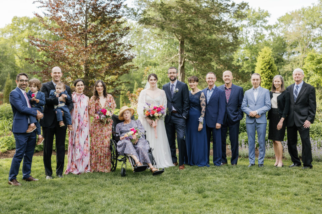 The bride and groom stand with their family on either side of them