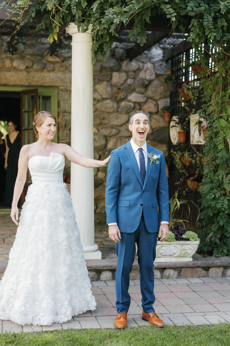 The groom is smiling as the bride puts her hand on his shoulder